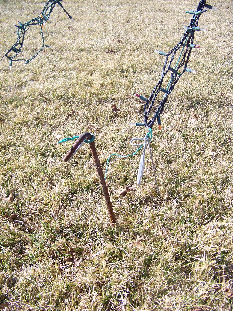 100_1292.jpg - We cut 18" pieces of rebar, then bent a 'j' hook. Once we pounded it in, then the lights strings 'core' 14 gauge wire is pulled tight with turn-buckles. This kept the strings from flapping in the high wind.